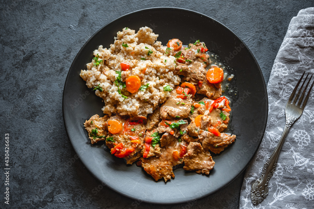 Beef stew in gravy with vegetables, served with barley Beef stew in gravy with vegetables, served with barley