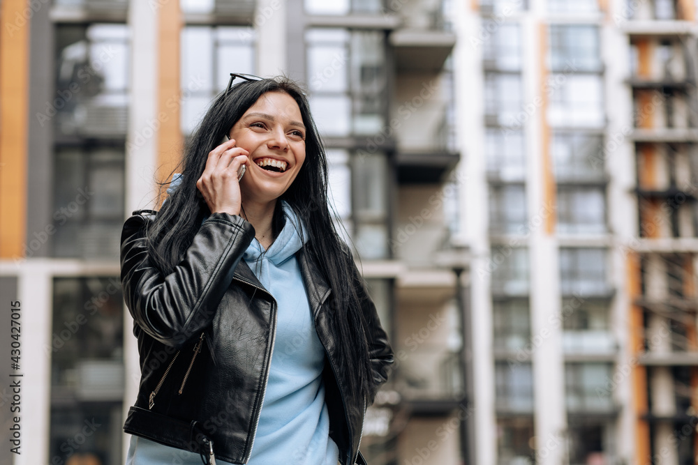 Young beautiful brunette girl talking on the phone and laughing