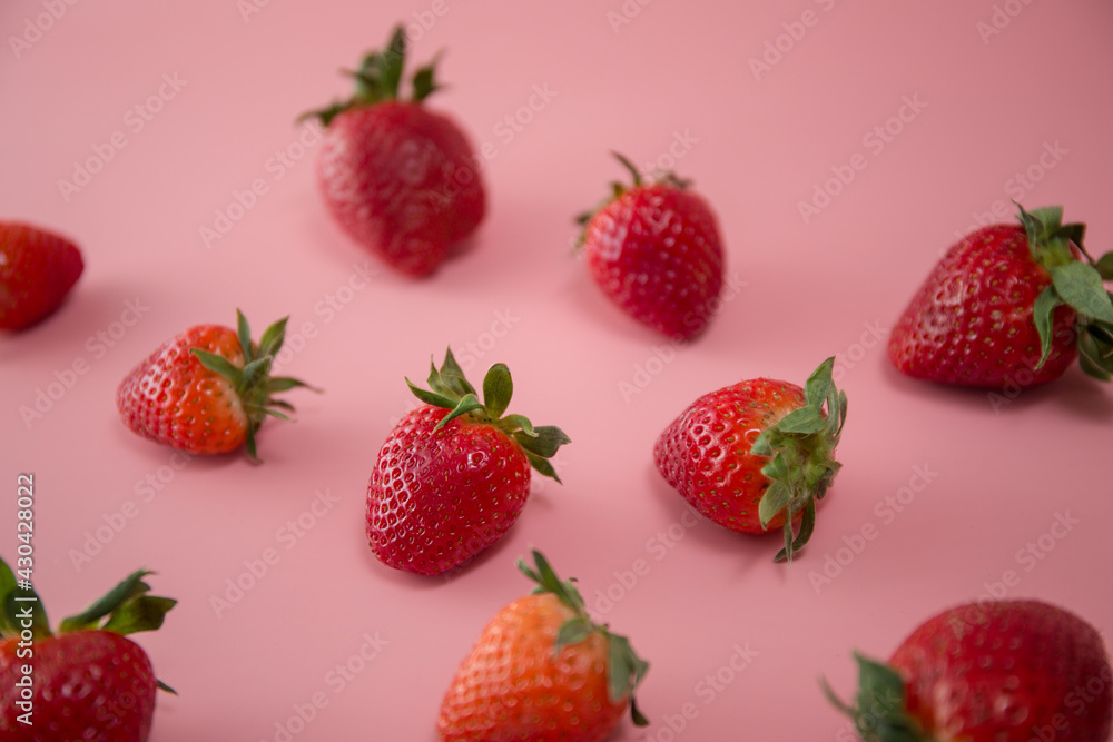 Delicious juicy ripe red strawberries on a pink background. Close-up shot of strawberries on a grater. Berry pattern Delicious juicy ripe red strawberries on a pink background. Close-up shot of strawberries on a grater. Berry pattern
