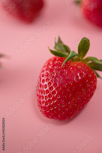 Delicious juicy ripe red strawberries on a pink background. Close-up shot of strawberries on a grater. Macro shot of garden strawberry
