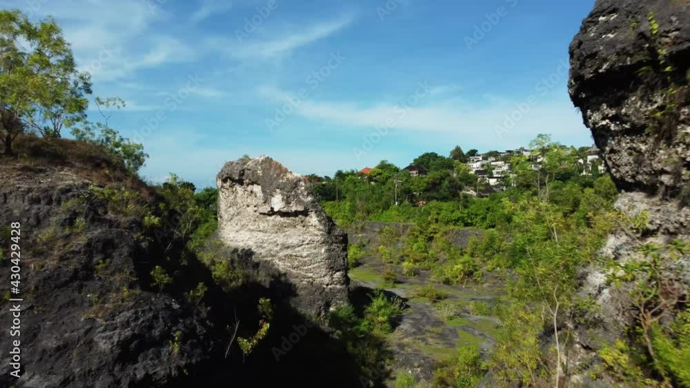 Drone forward flight close over the green trees between rocks with beautiful sky in Bali Indonesia. High quality 4k aerial footage Drone forward flight close over the green trees between rocks with beautiful sky in Bali Indonesia. High quality 4k aerial footage
