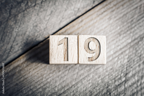 Number 19 Formed By Wooden Blocks On A Board photo