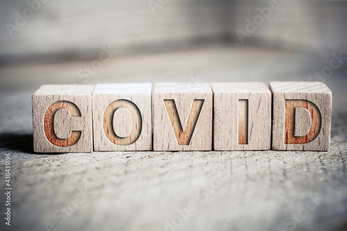 Covid Written On Wooden Blocks On A Board photo