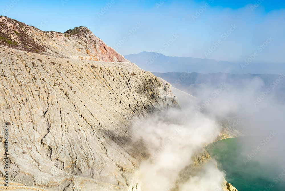 Ijen volcano crater with lake and sulphur mining. Beautiful Landscape mountain and green lake with smoke sulfur in the morning in a Kawah Ijen volcano. Beautiful landmark from East Java, Indonesia Ijen volcano crater with lake and sulphur mining. Beautiful Landscape mountain and green lake with smoke sulfur in the morning in a Kawah Ijen volcano. Beautiful landmark from East Java, Indonesia