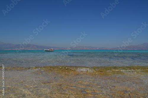 Boat on the sea surface against the background of Crete island
