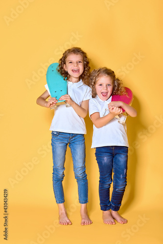 Two Active and happy girls with curly hair having fun with penny