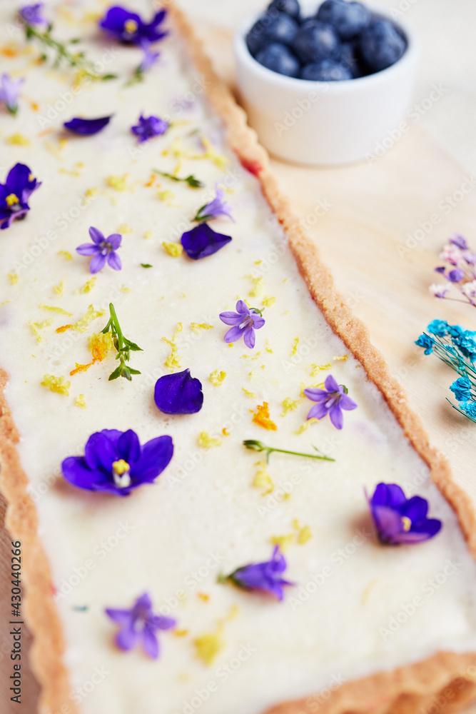 cheesecake with blue flowers on a light background with berries close-up