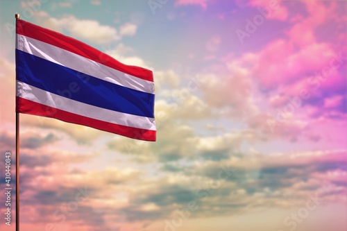 Fluttering Thailand flag mockup with the space for your content on colorful cloudy sky background.
