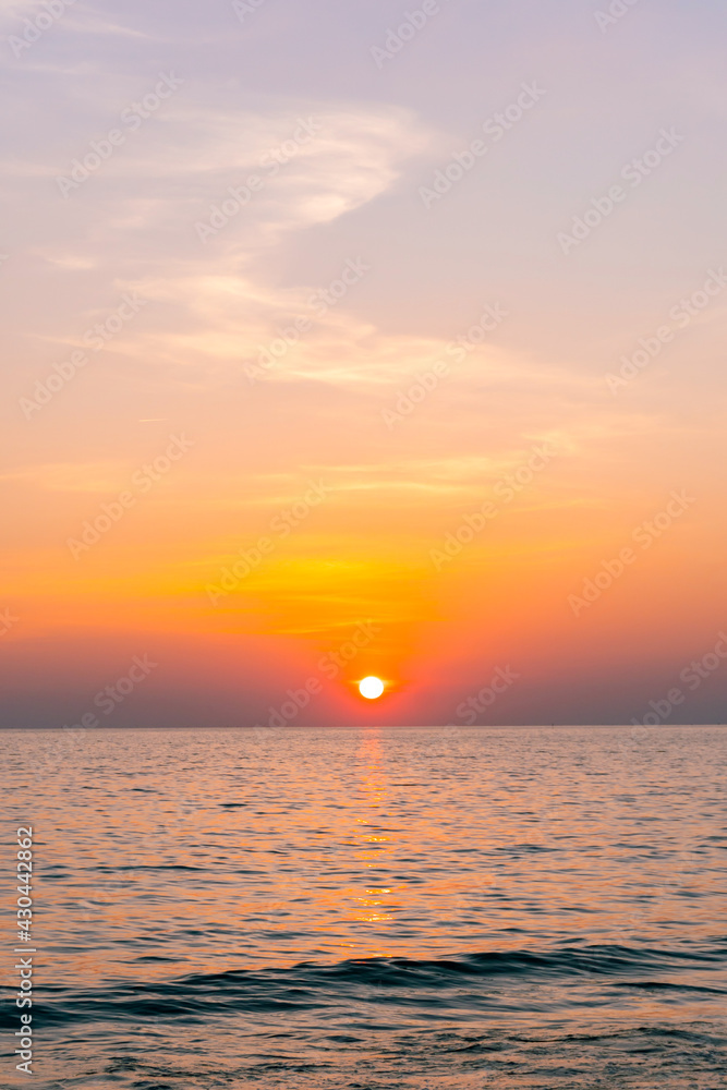 Sunset reflection sea. beautiful sunset behind the clouds and blue sky above the over sea landscape background Sunset reflection sea. beautiful sunset behind the clouds and blue sky above the over sea landscape background