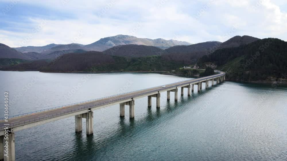Aerial view of bridge road with cars over an idyllic lake in mountain landscape. High quality 4k footage Aerial view of bridge road with cars over an idyllic lake in mountain landscape. High quality 4k footage