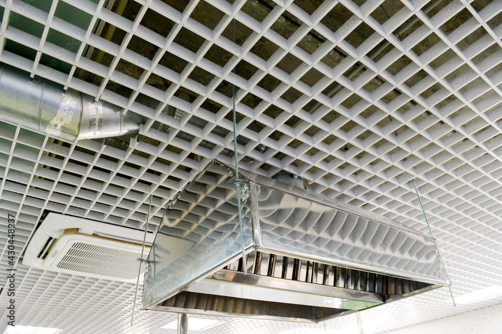 Obraz premium Suspended metal hood against the background of the lattice ceiling. Kitchen equipment.