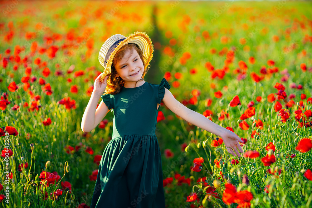 Girl in dress and straw hat outdoor At Poppy Field Girl in dress and straw hat outdoor At Poppy Field