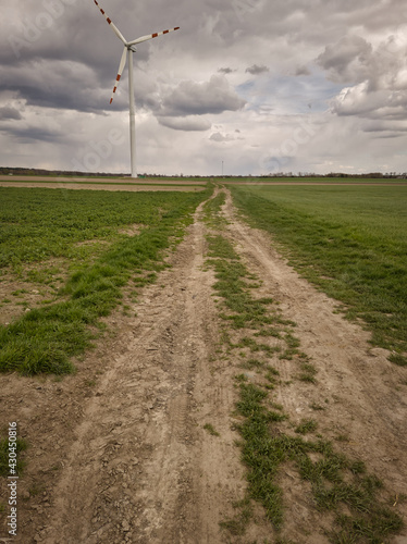 WIATRAK. WIDOK NA WIATRAK NA POLU W POCHMURNY DZIEŃ.