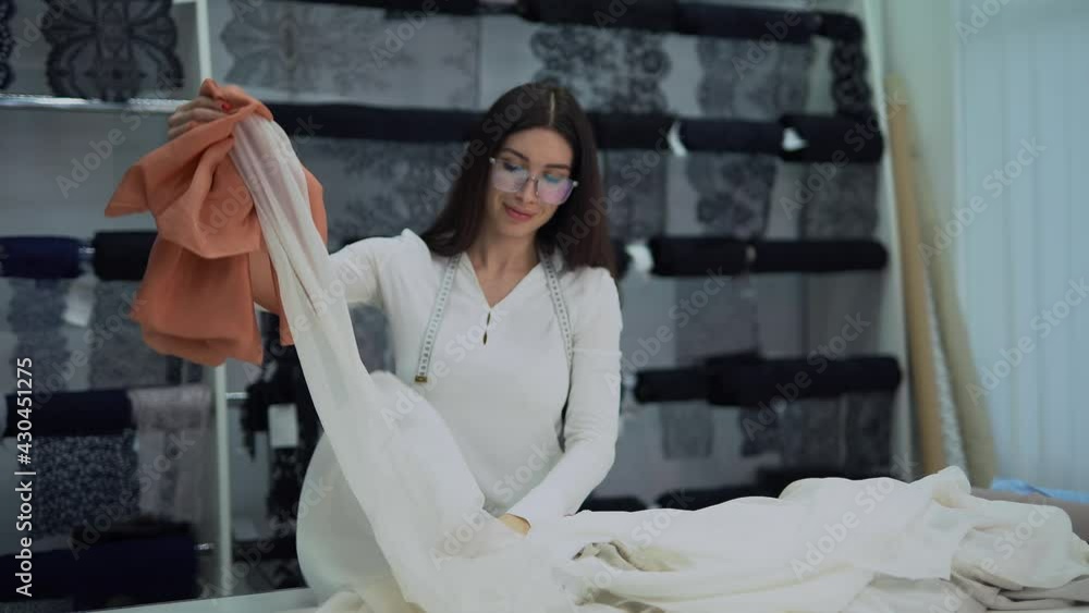 Fashion, tailoring, couture and seamstress concept. Professional caucasian female dressmaker, designer or seamstress folding textile clothes in atelier or studio. 4k high quality footage Fashion, tailoring, couture and seamstress concept. Professional caucasian female dressmaker, designer or seamstress folding textile clothes in atelier or studio. 4k high quality footage