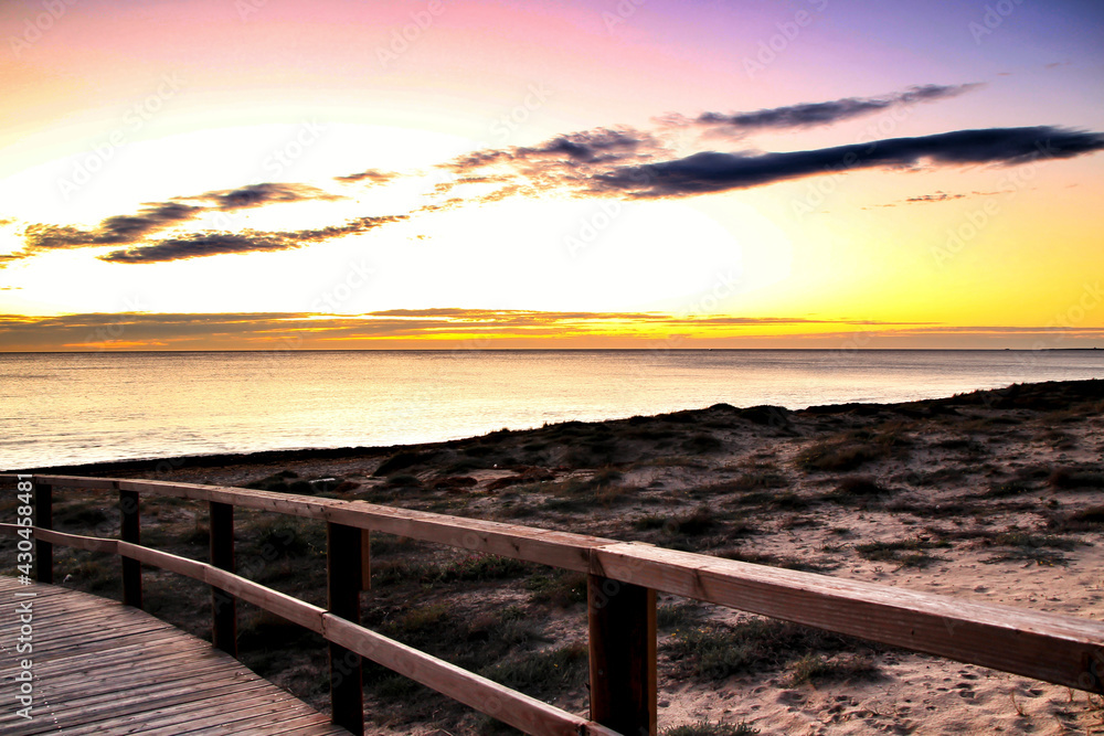 Obraz premium Wooden walkway to the beach at sunrise in Alicante, Spain