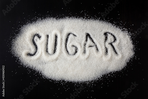 Obraz na płótnie Heap of granulated white sugar on black background w salonie