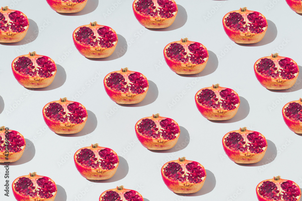Pattern made with fresh pomegranate on a gray background. Minimal concept of fruit or food. Flat lay, top view. Pattern made with fresh pomegranate on a gray background. Minimal concept of fruit or food. Flat lay, top view.