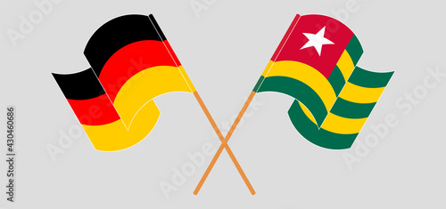 Crossed and waving flags of Germany and Togo