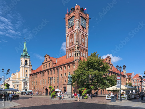 Torun, Poland. Old Town Market Square with Nicolaus Copernicus Monument in front of the Old Town Hall, and Church of the Holy Spirit in the background. The monument was erected in 1853.