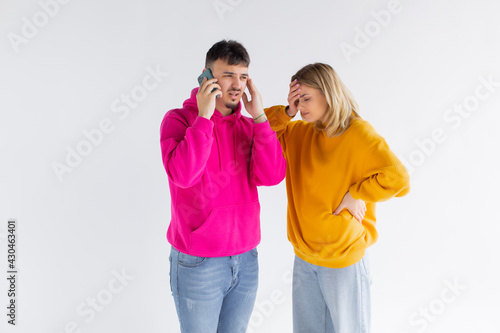 Image of young woman spying and peeking at cellphone of her boyfriend isolated over white background