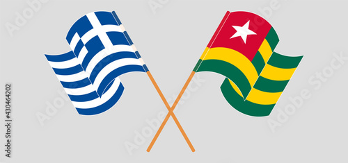 Crossed and waving flags of Greece and Togo
