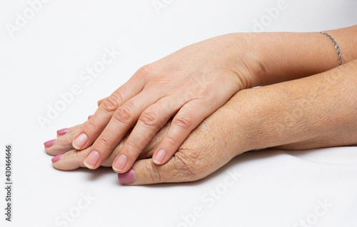 close-up shot of young person hands holding tenderly the hand of an elderly person