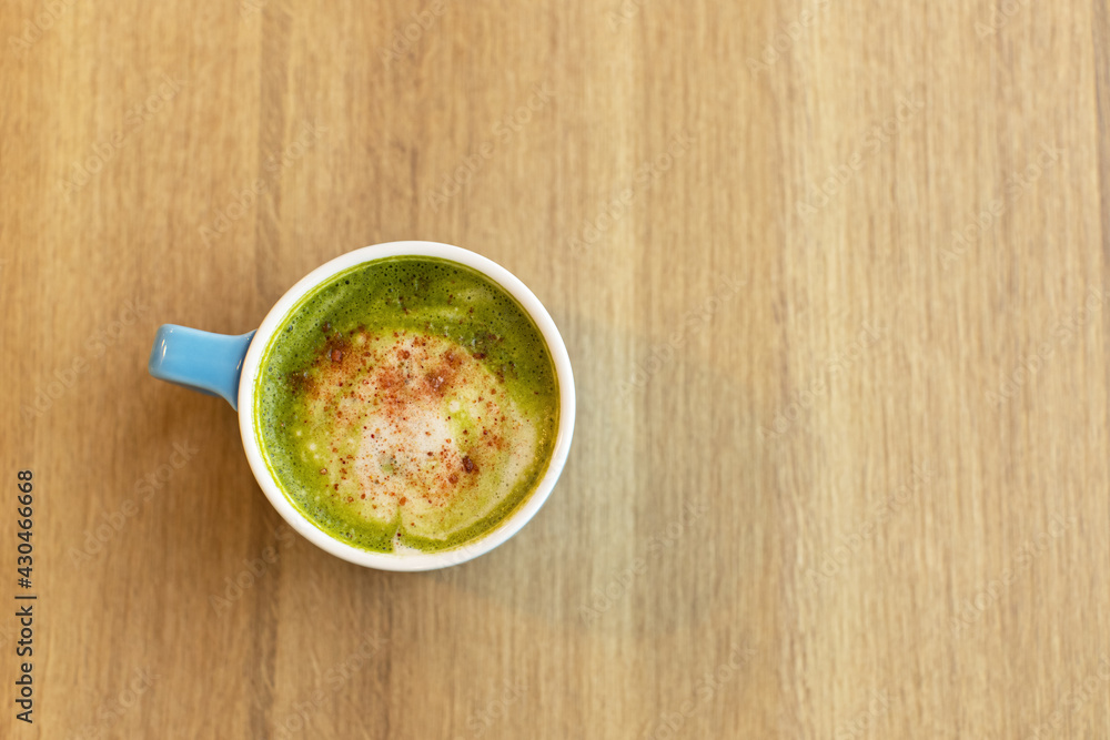 Blue cup with green tea matcha latte, with freeze-dried strawberries on wooden table, copy space. Healthy nutrition concept, drinks with vegetable or cow's milk, vegan beverages. Place for text Blue cup with green tea matcha latte, with freeze-dried strawberries on wooden table, copy space. Healthy nutrition concept, drinks with vegetable or cow's milk, vegan beverages. Place for text