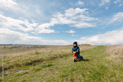 Two active little sibling boys having fun on bikes in the mountains on cold day.