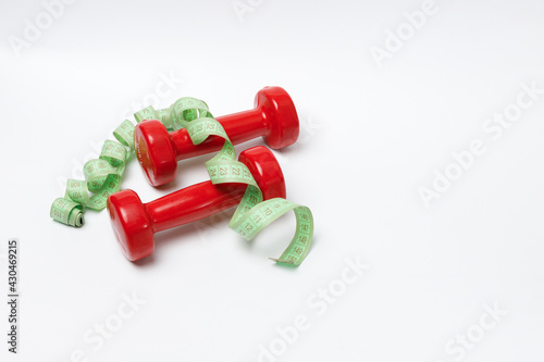 red kilogram dumbbells and centimeters on a white background