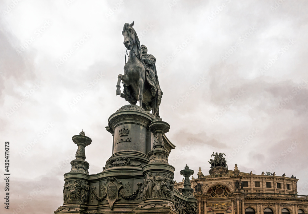 Dresden, Germany - May 02 2019: statue of the Saxon King Johann at the facade of the Semper Opera, and the royal palace-residence, sculptor - Johannes Schilling, installed in 1889 on the Theaterplatz