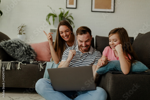 фотографія Overjoyed family sit relax on couch at home feel euphoric win online lottery on laptop