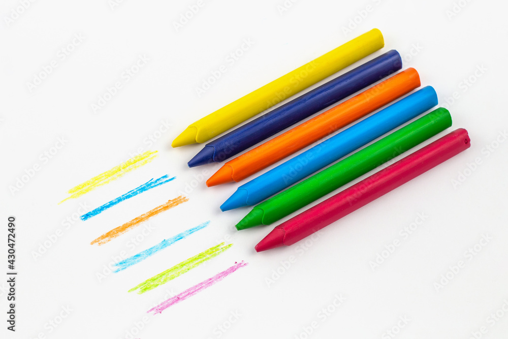 Fototapeta premium wax crayons in a row on white paper