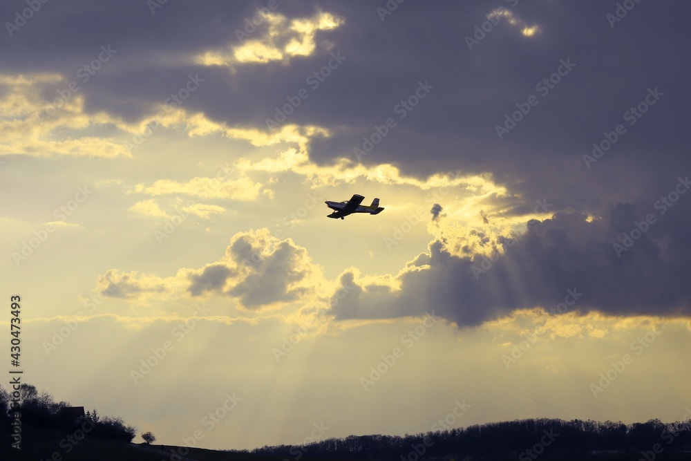 A plane on the sky with beautiful violet clouds and sunset in background at Brno, Czech republic