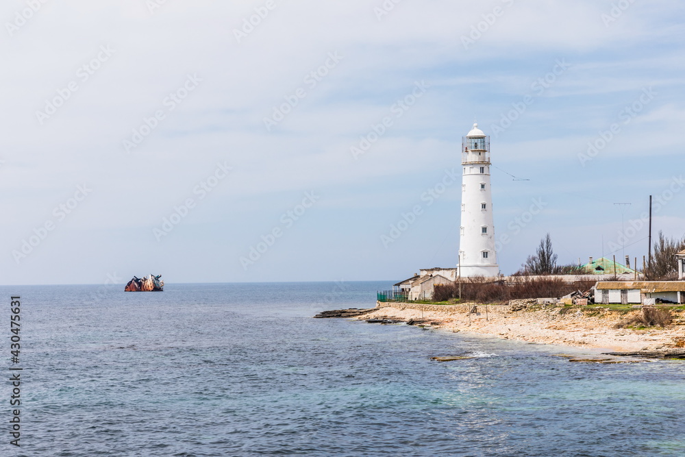 Rocky coast of the Tarkhankut peninsula - the westernmost part of Crimea. The white lighthouse