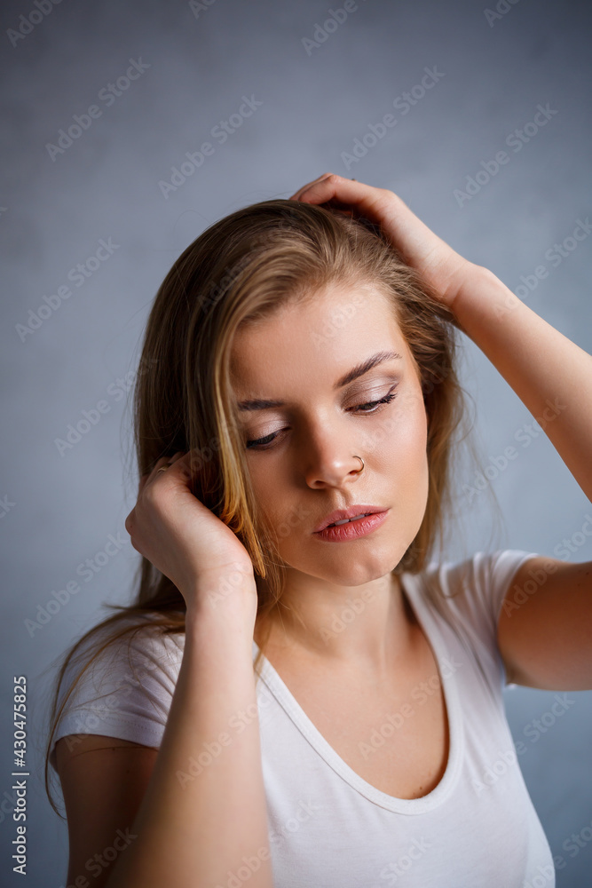 Obraz premium Close up portrait of a beautiful young woman. Emotional photo of a girl. Dressed in a white t-shirt
