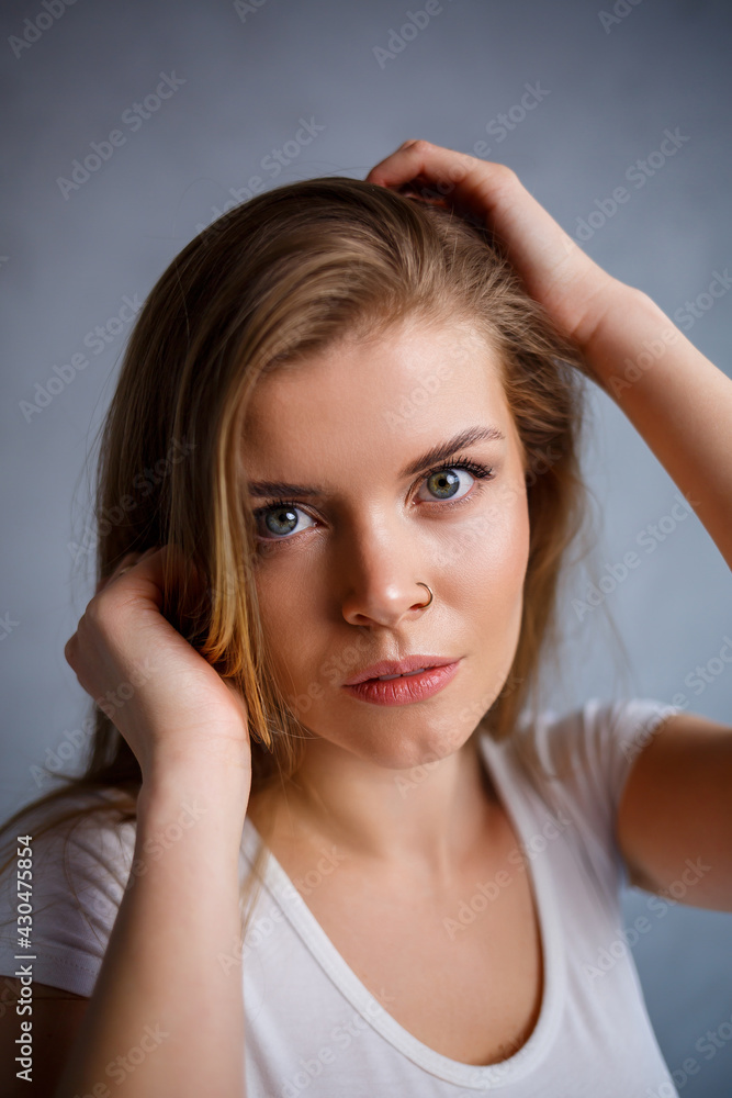 Obraz premium Close up portrait of a beautiful young woman. Emotional photo of a girl. Dressed in a white t-shirt