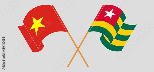 Crossed and waving flags of Vietnam and Togo