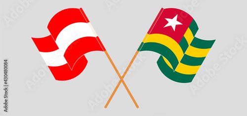 Crossed and waving flags of Austria and Togo