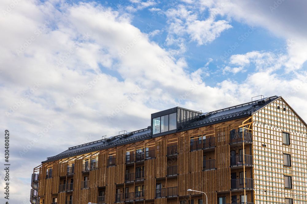 Close up view of new modern building on blue sky and white clouds background. Close up view of new modern building on blue sky and white clouds background.