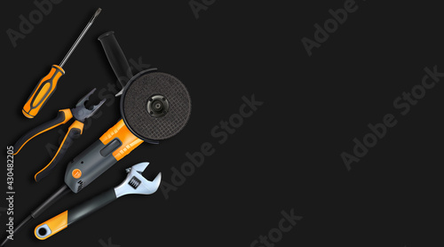 Orange tools professional realistic on black background. Angle grinder, adjustable wrench, screwdriver and pliers. 3d composition for labor day. Copy-space.