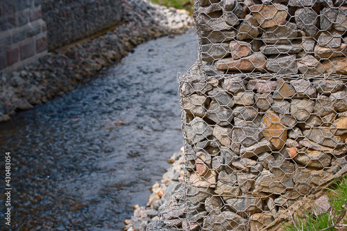 Bridge abutment with gabions. Gabion wall constructed using steel wire mesh basket. Stone walls, protection from backshore erosion. Gabion and rock armour - coastal and waterways protection. photo
