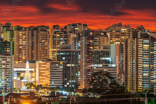 Cityscape at dusk on a powerful sunset and lights of the city turning on. Photo of Gleba Palhano neighborhood at Londrina city, PR, Brazil.