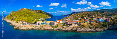 Turquoise colored bay in Mediterranean sea with beautiful colorful houses in Assos village in Kefalonia, Greece. Town of Assos with colorful houses on the mediterranean sea, Greece.