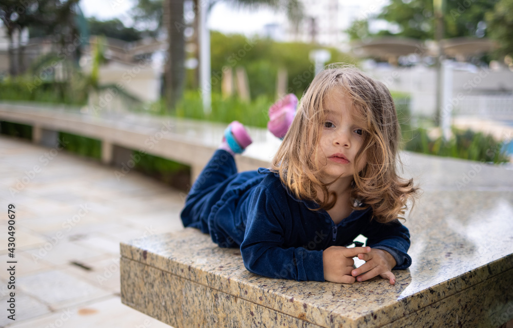 menina de 2 anos deitada sobre o mármore usando roupa azul e cabelos ...