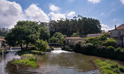 Rural landscape in Portugal with river. River Este in Touguinho, Vila do Conde, Portugal with historic stone bridge