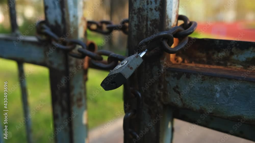 Rusty Closed Metal Gate Secured with Iron Chain and Simple Padlock Rusty Closed Metal Gate Secured with Iron Chain and Simple Padlock