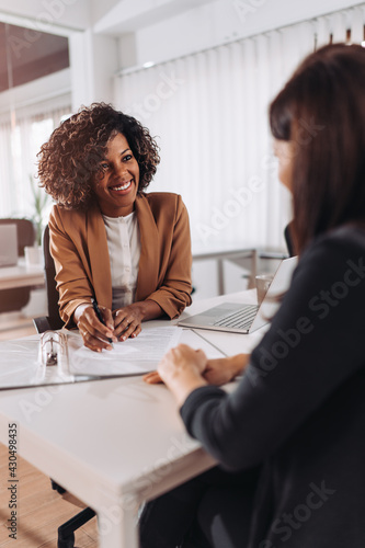 Woman consulting with a female financial manager at the bank photo