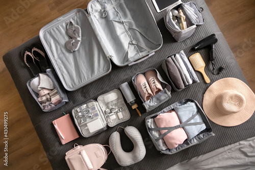 Fotografie Top view composition with neatly packing things, clothes and accessories for tra