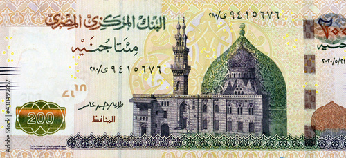 A fragment of the obverse side of 200 Egyptian pounds banknote, obverse side has an image of Mosque of Qani-Bay Cairo, Egypt. The reverse side has an image of The Seated Scribe photo