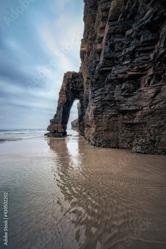 Stone arch on the famous beach of Las Catedrales, in Galicia, Spain.